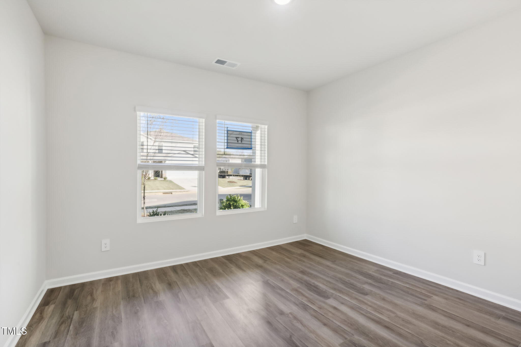 185 White Birch Lane Angier, NC 27501 - Photo 13 of 27 an empty room with wooden floor and windows