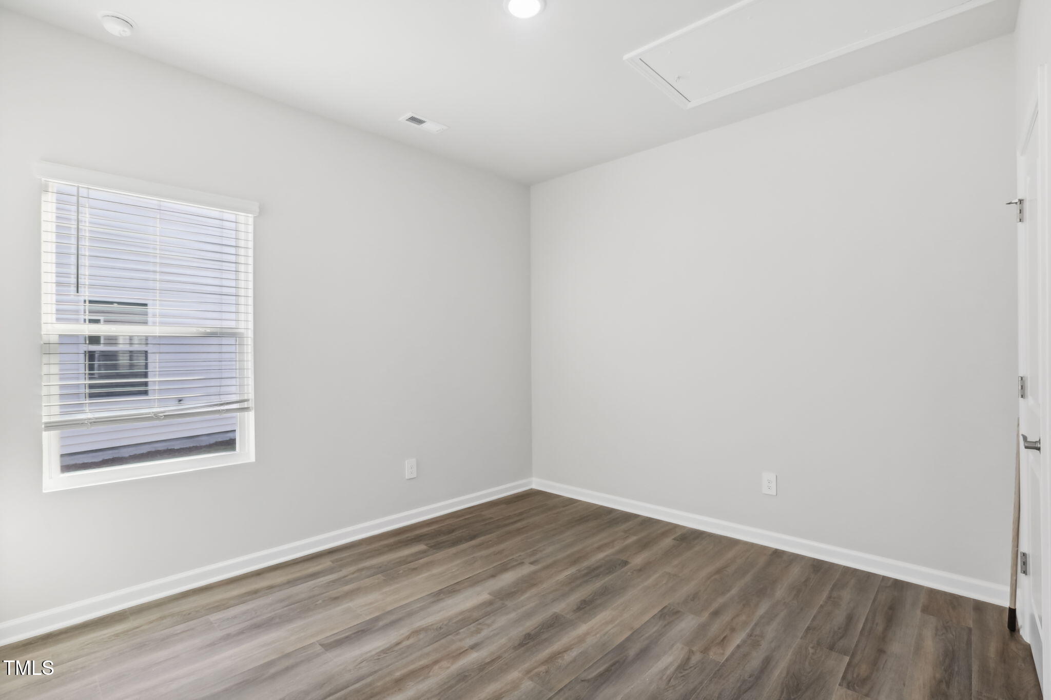 185 White Birch Lane Angier, NC 27501 - Photo 16 of 27 a view of an empty room with wooden floor and a window