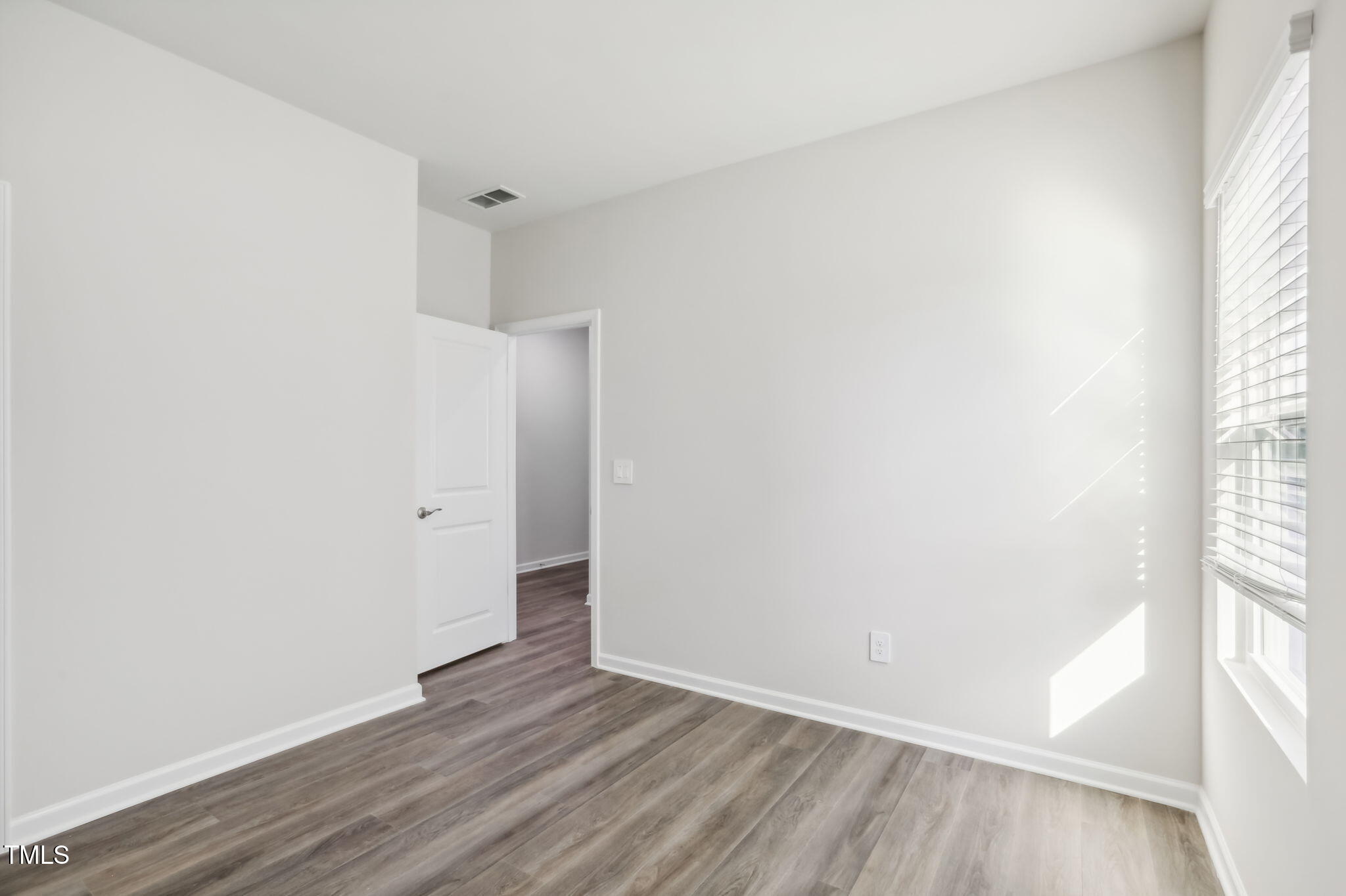 185 White Birch Lane Angier, NC 27501 - Photo 17 of 27 a view of an empty room with wooden floor and a window