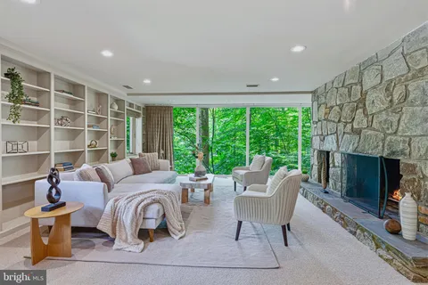 a living room with furniture large window and a fireplace