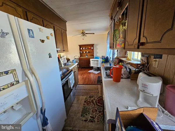 a living room with furniture and a white refrigerator