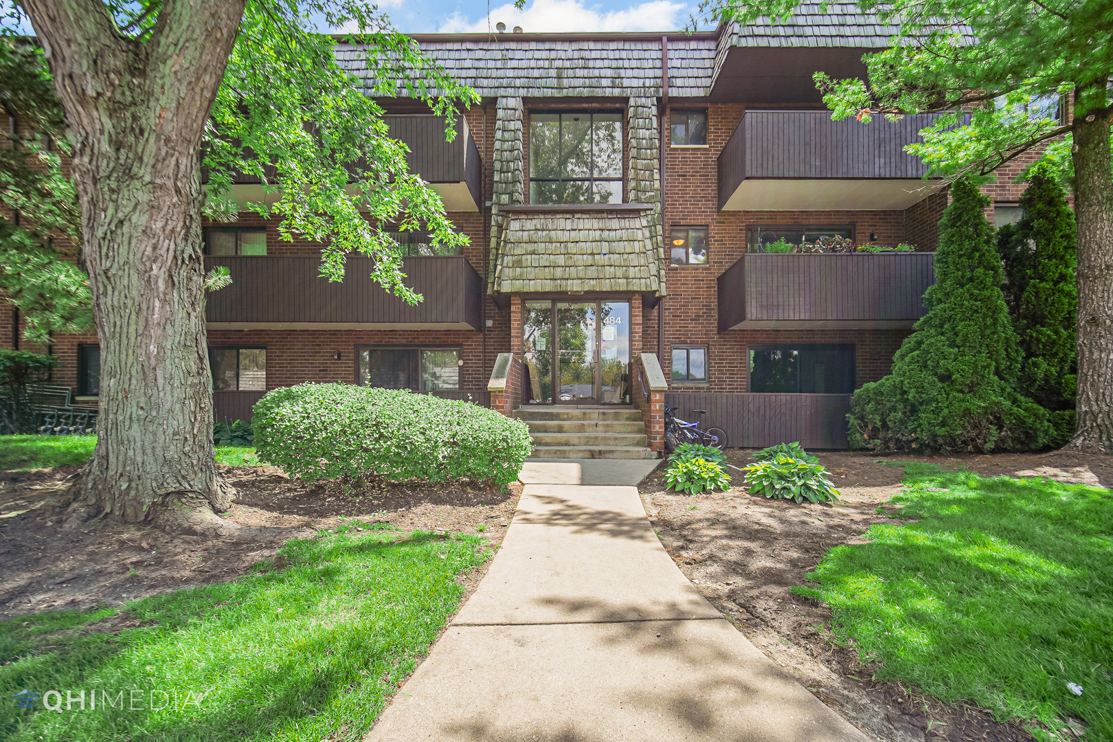 484 Timber Ridge Drive, Unit 106 Carol Stream, IL 60188 - Photo 1 of 23 a front view of a house with garden