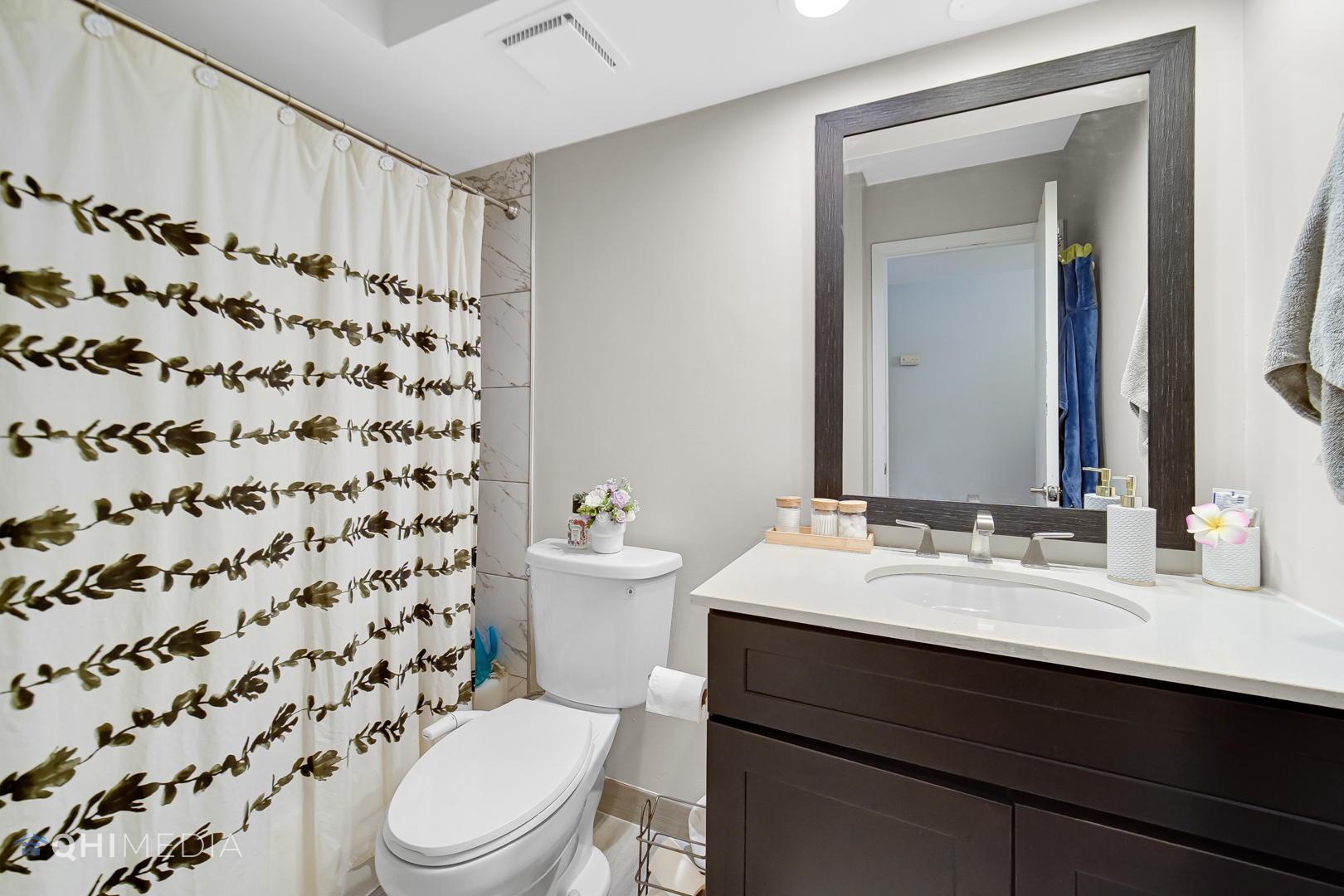 484 Timber Ridge Drive, Unit 106 Carol Stream, IL 60188 - Photo 15 of 23 a bathroom with a sink a toilet a mirror and shower curtain