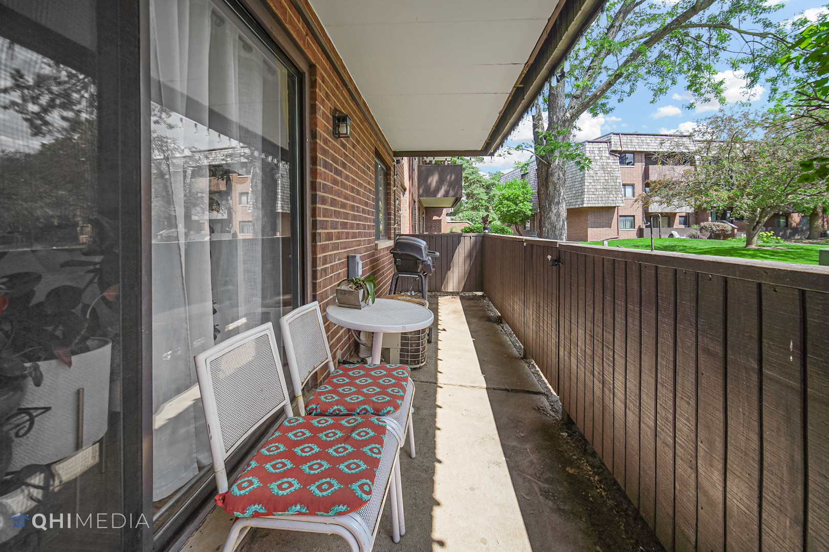 484 Timber Ridge Drive, Unit 106 Carol Stream, IL 60188 - Photo 20 of 23 a balcony with wooden floor and outdoor seating