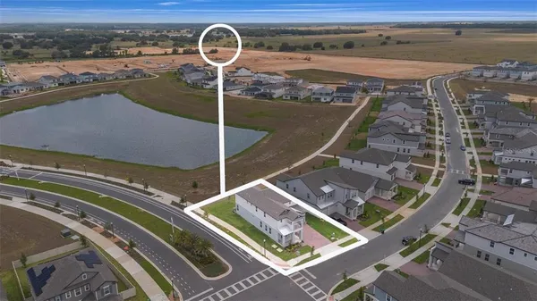 an aerial view of residential houses with outdoor space and parking