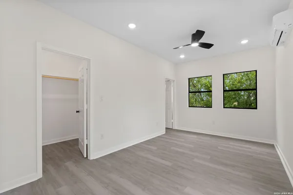 an empty room with wooden floor and windows