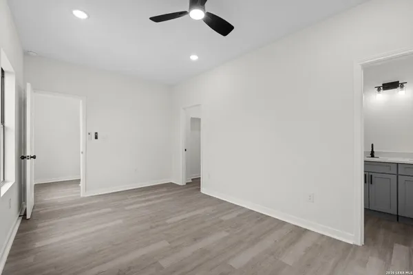 an empty room with wooden floor cabinet and a ceiling fan