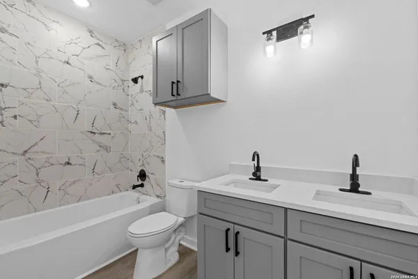 a bathroom with a sink a toilet and shower