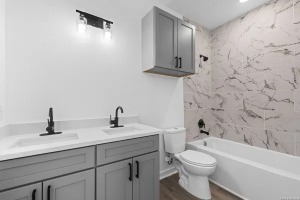 a bathroom with a sink a toilet and shower