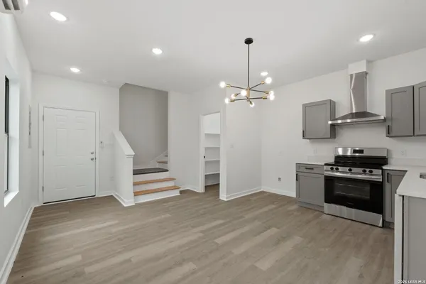 a view of a kitchen with electric appliances and wooden floor