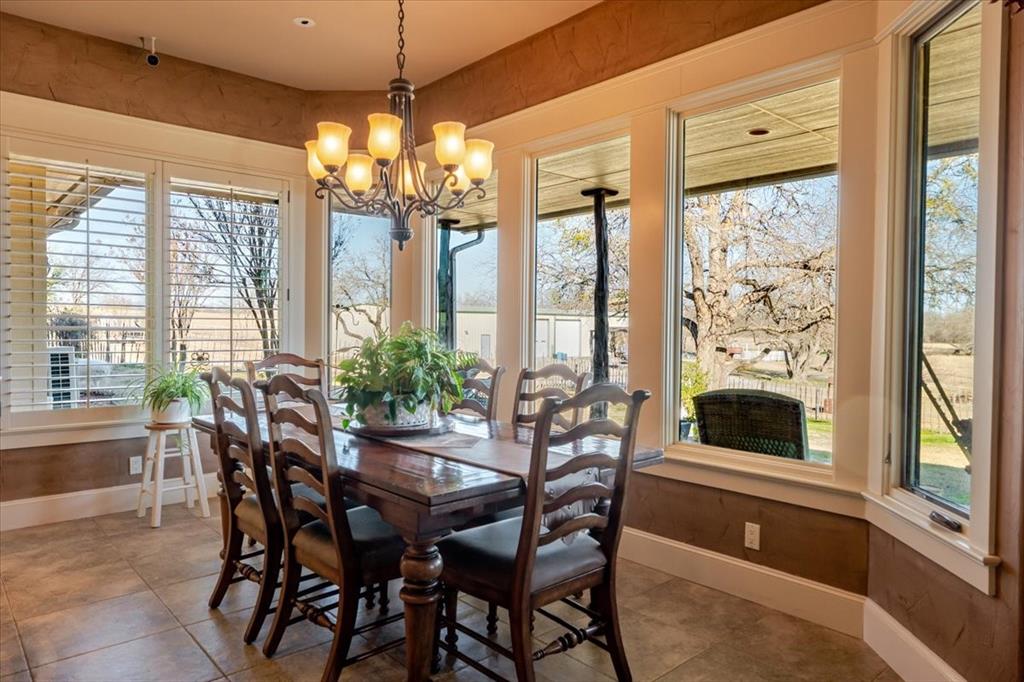 11918 Riek Road Krum, TX 76249 - Photo 17 of 40 a dining room with furniture large windows and a chandelier