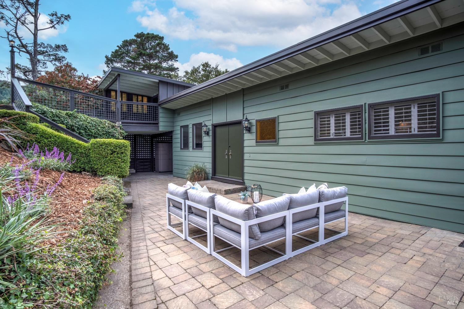 a view of a chairs and table in the back yard of the house