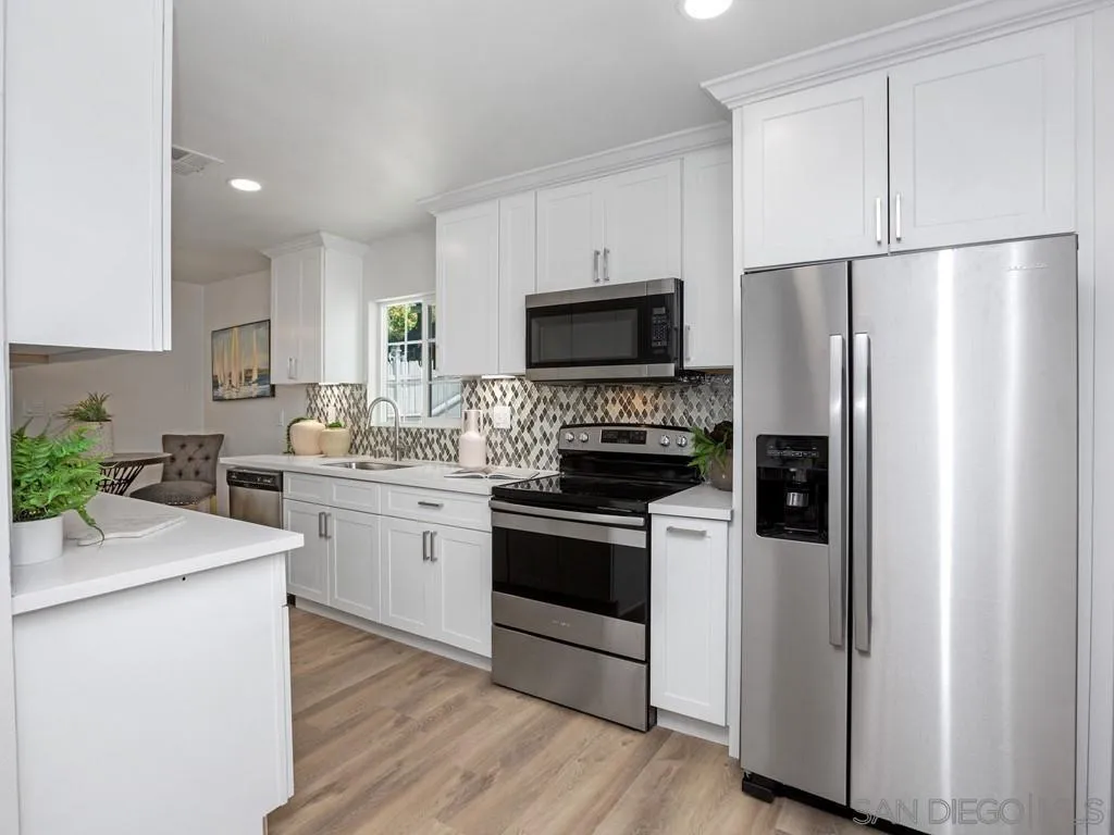 4765 Maple Avenue La Mesa, CA 91942 - Photo 7 of 26 a kitchen with white cabinets and stainless steel appliances