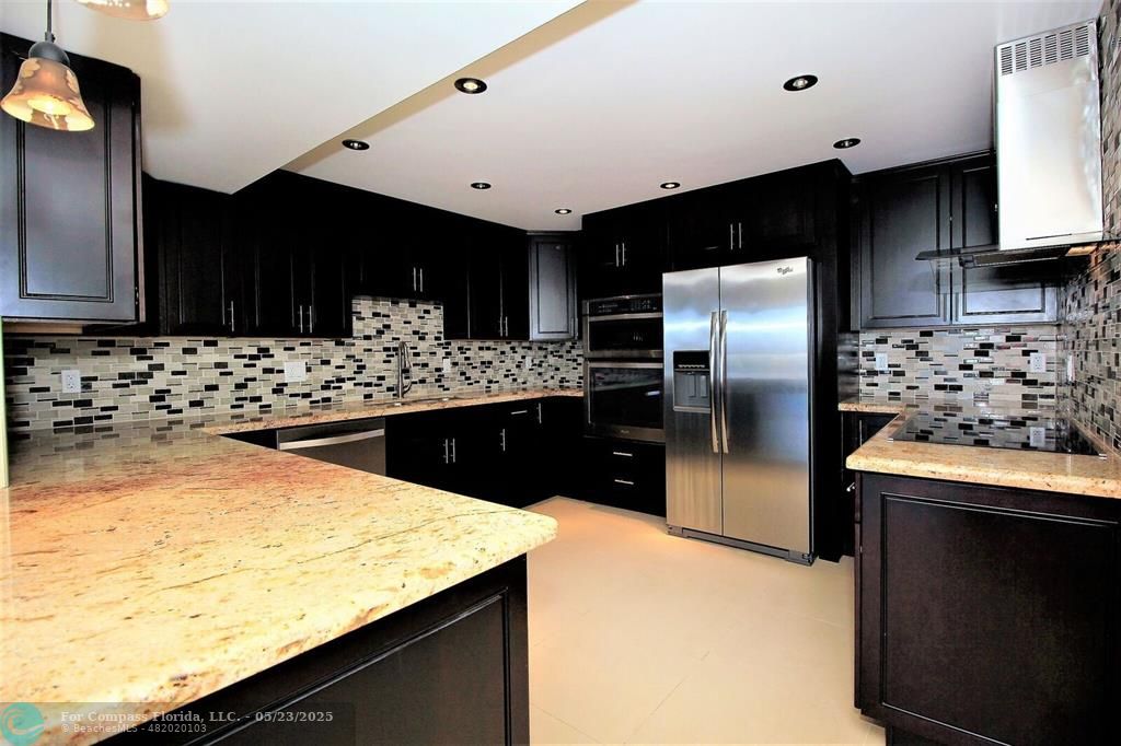 1360 South Ocean Boulevard, Unit 2806 Pompano Beach, FL 33062 - Photo 15 of 37 a kitchen with stainless steel appliances kitchen island granite countertop a refrigerator a stove and a sink