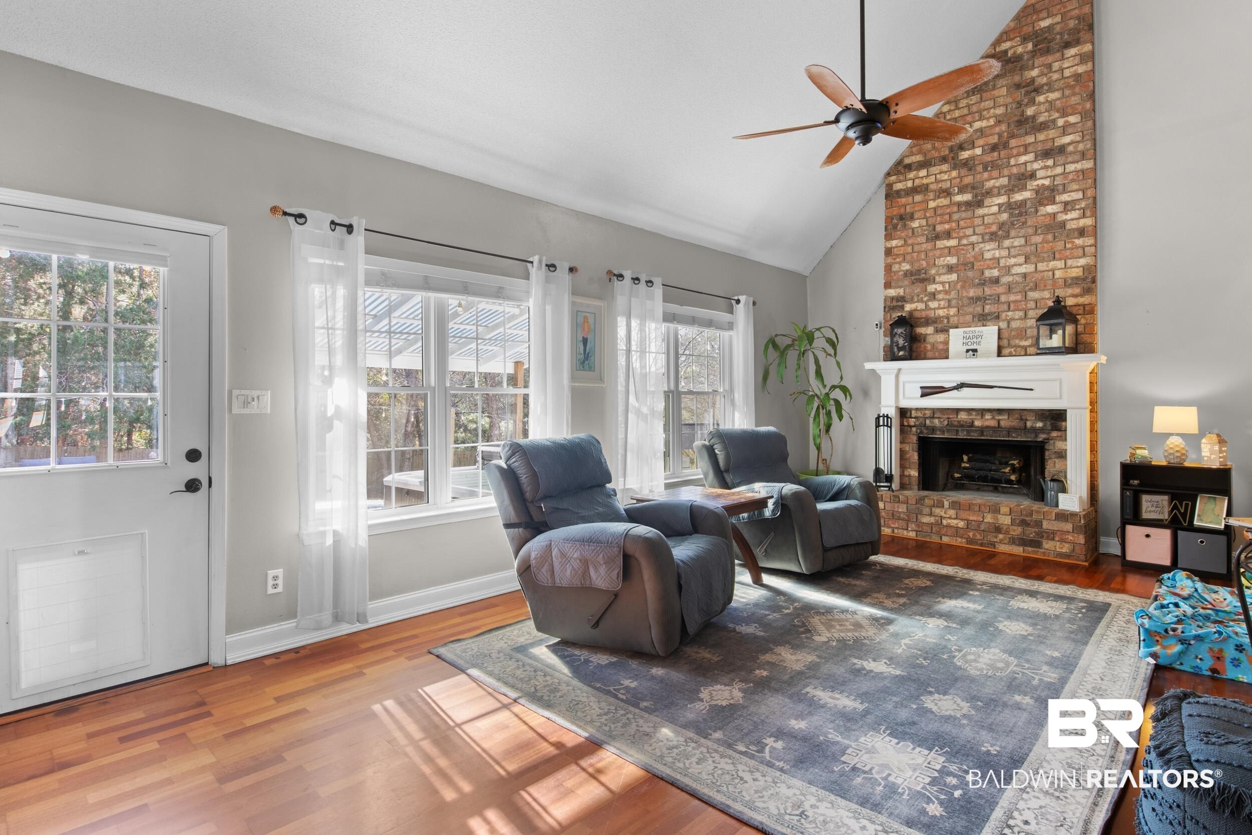 131 Marikesh Drive Daphne, AL 36526 - Photo 17 of 29 Living room featuring hardwood / wood-style floors, high vaulted ceiling, a brick fireplace, and ceiling fan