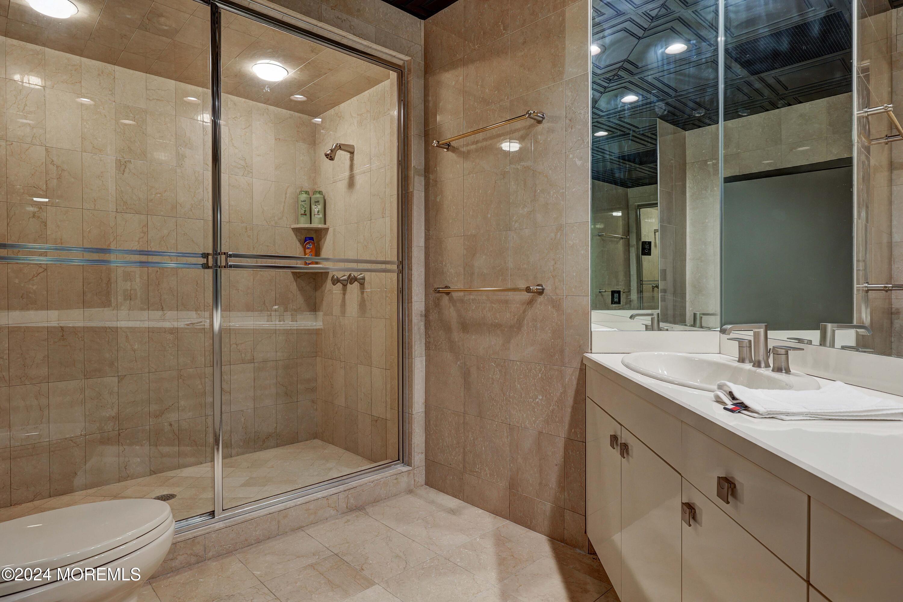 1980 Campbell Road Wall, NJ 07719 - Photo 74 of 110 a bathroom with a shower sink vanity and mirror