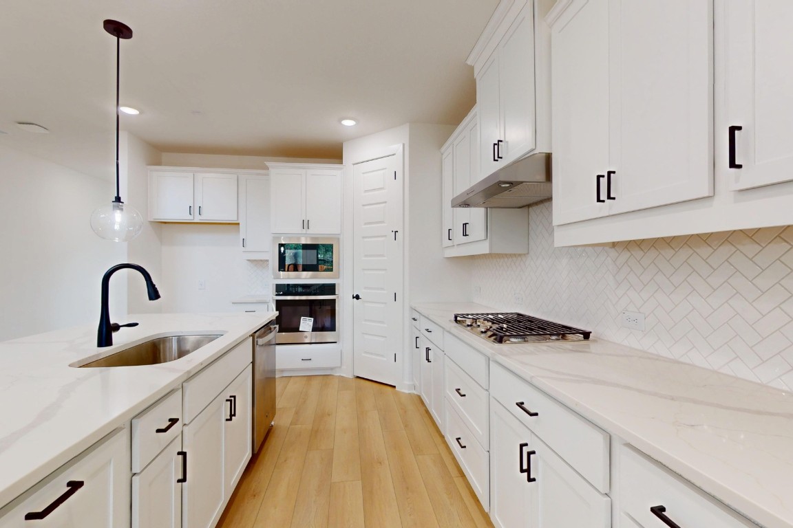 3913 Waxahachie Road Leander, TX 78641 - Photo 12 of 39 a kitchen with stainless steel appliances granite countertop a sink a stove and a refrigerator