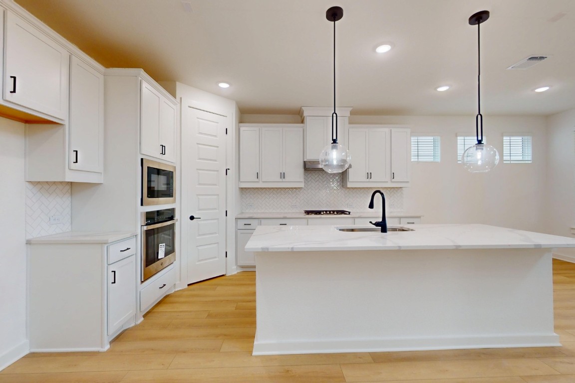 3913 Waxahachie Road Leander, TX 78641 - Photo 13 of 39 a large kitchen with stainless steel appliances granite countertop a sink a stove and a refrigerator