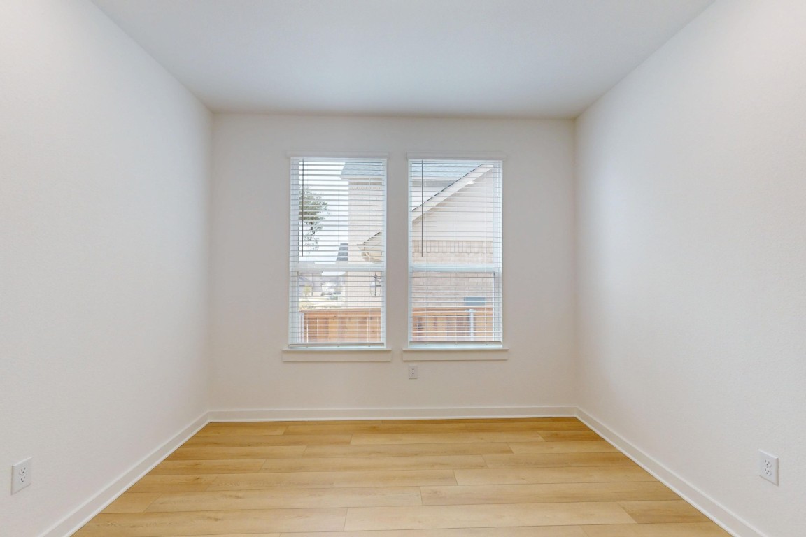 3913 Waxahachie Road Leander, TX 78641 - Photo 17 of 39 an empty room with wooden floor and windows