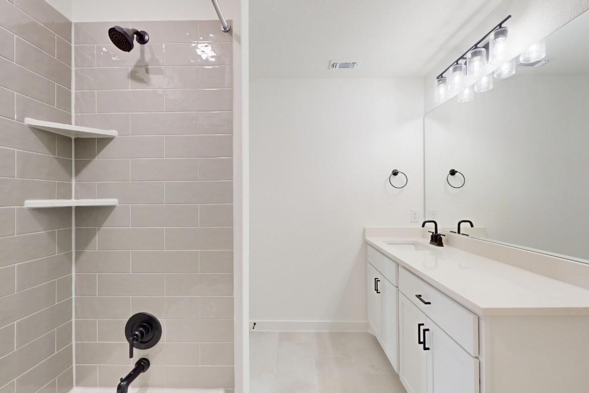 3913 Waxahachie Road Leander, TX 78641 - Photo 29 of 39 a bathroom with a sink a vanity a mirror and shower