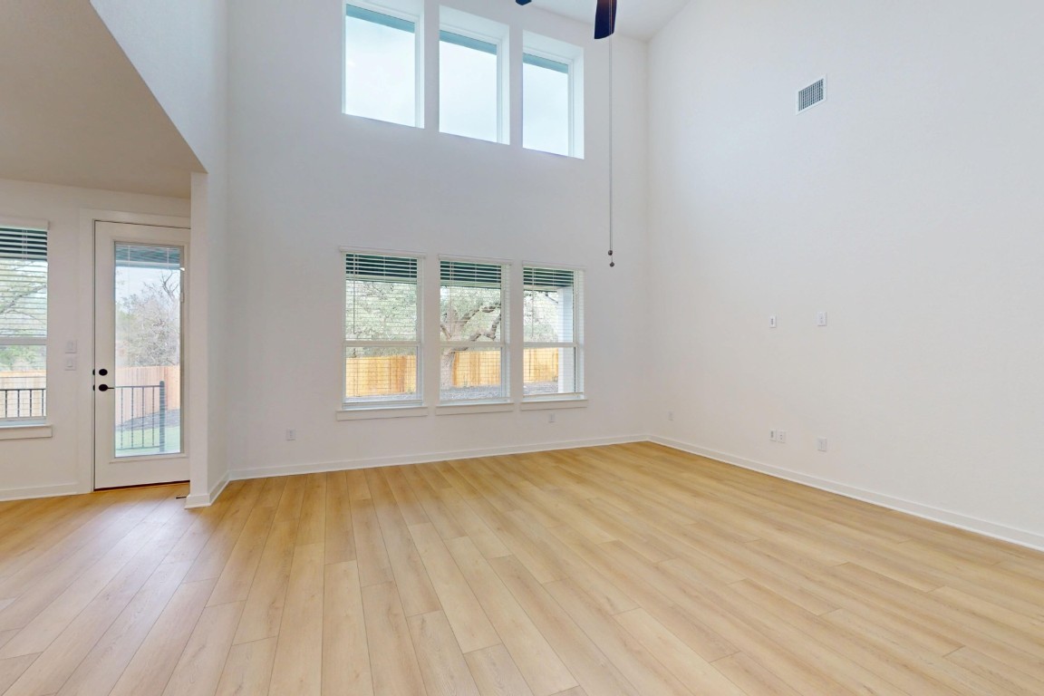 3913 Waxahachie Road Leander, TX 78641 - Photo 5 of 39 an empty room with wooden floor and windows