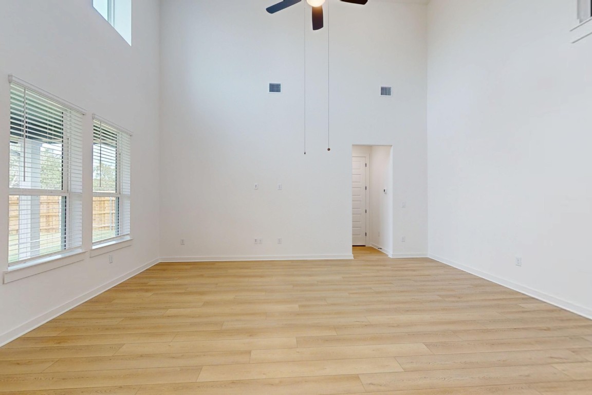 3913 Waxahachie Road Leander, TX 78641 - Photo 6 of 39 a view of an empty room with wooden floor and a window