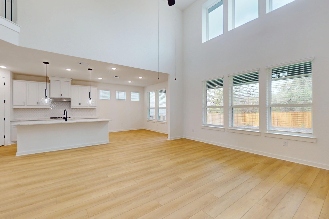 3913 Waxahachie Road Leander, TX 78641 - Photo 7 of 39 a view of large kitchen with kitchen island a sink wooden floor and a large window