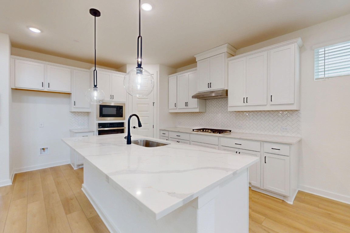 3913 Waxahachie Road Leander, TX 78641 - Photo 10 of 39 a kitchen with stainless steel appliances granite countertop a sink a stove and a refrigerator