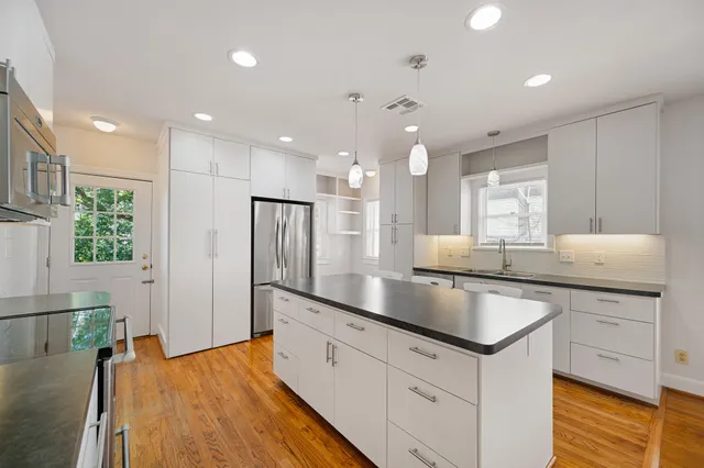 a kitchen with stainless steel appliances granite countertop refrigerator sink and cabinets