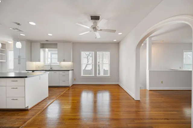 a large kitchen with cabinets wooden floor and stainless steel appliances