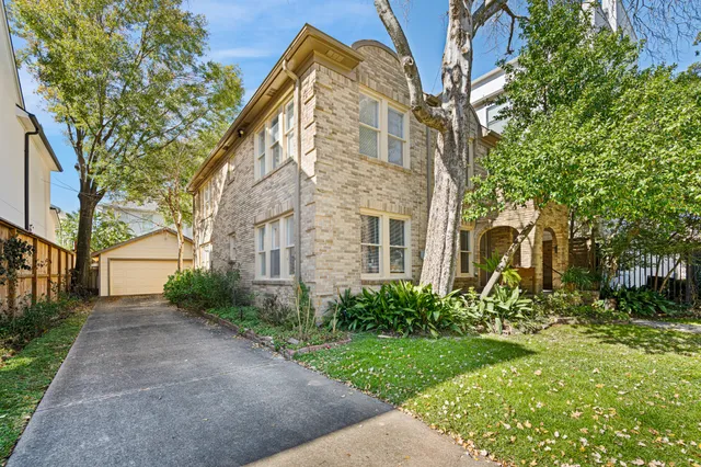 a backyard of a brick building with large trees