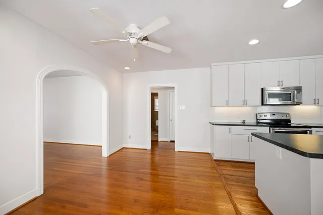 a kitchen with stainless steel appliances granite countertop a refrigerator a stove and a sink