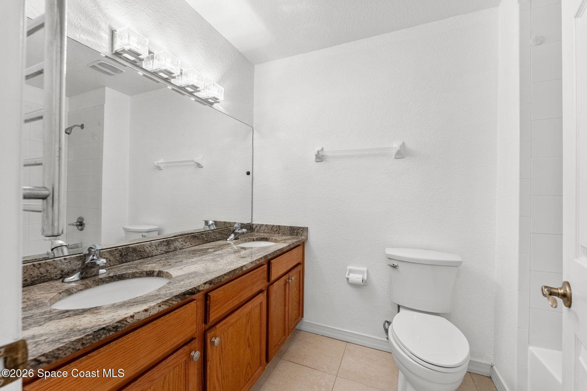 110 Turpial Way, Unit 106 Melbourne, FL 32901 - Photo 34 of 50 a bathroom with a granite countertop sink toilet and a mirror