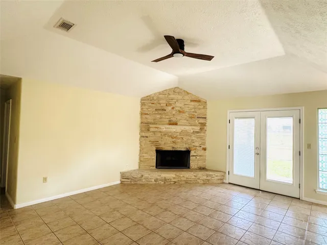 an empty room with fireplace and fan