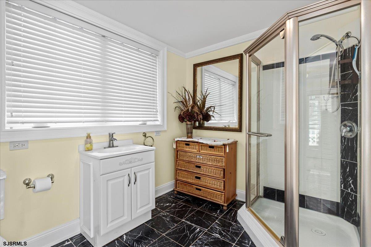 104 South Oakland Avenue, Unit JULY '26 Ventnor City, NJ 08406 - Photo 12 of 57 a bathroom with a sink a mirror and a shower
