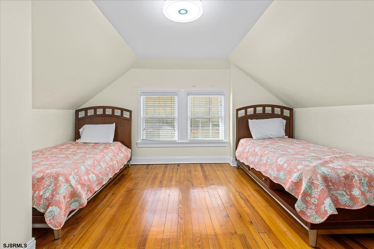 104 South Oakland Avenue, Unit JULY '26 Ventnor City, NJ 08406 - Photo 37 of 57 a bedroom with a bed and wooden floor