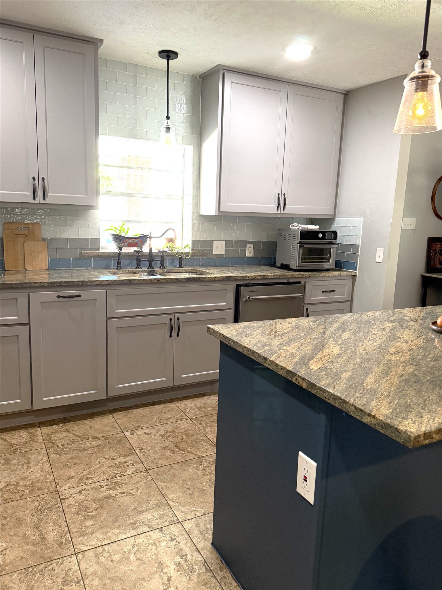 1002 Washington Street Brenham, TX 77833 - Photo 6 of 25 a kitchen with kitchen island granite countertop a sink a counter top space cabinets and stainless steel appliances