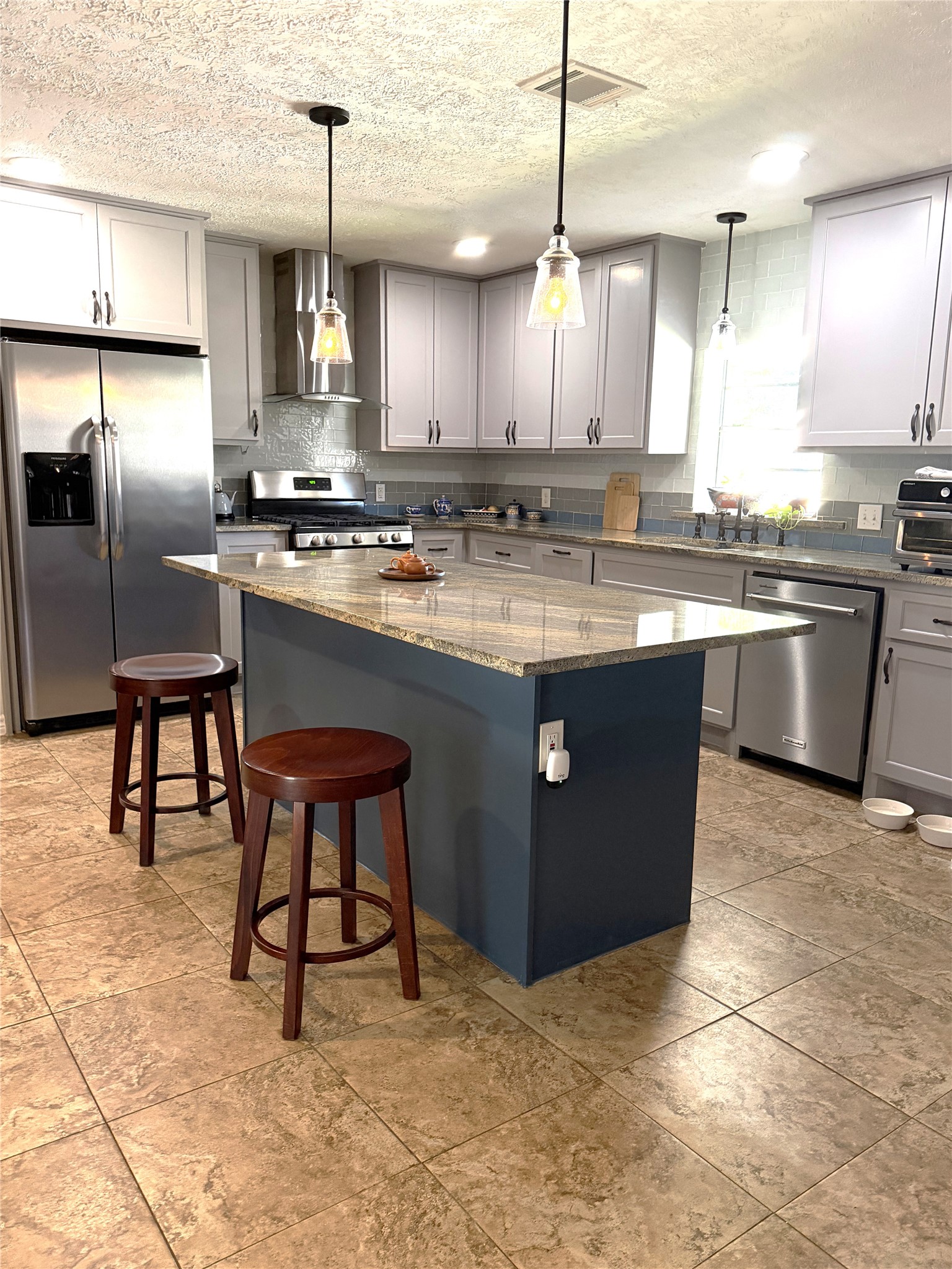 1002 Washington Street Brenham, TX 77833 - Photo 7 of 25 a kitchen with stainless steel appliances granite countertop a sink a stove a refrigerator and chairs