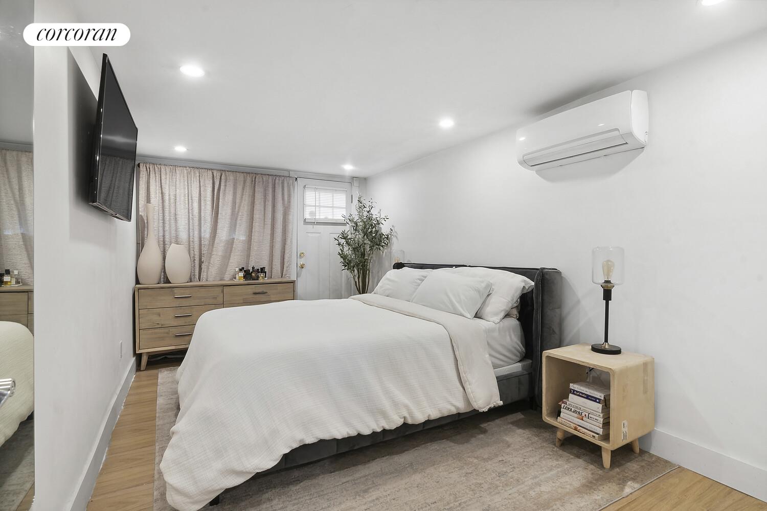 1079 Hancock Street Brooklyn, NY 11221 - Photo 18 of 22 a spacious bedroom with a bed and a chandelier