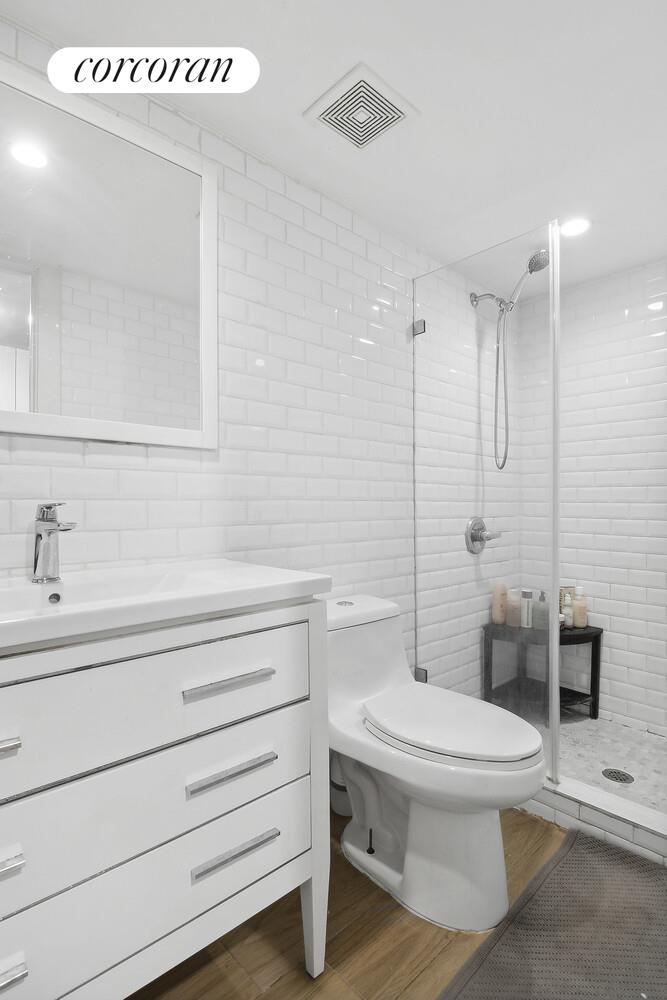 1079 Hancock Street Brooklyn, NY 11221 - Photo 20 of 22 a bathroom with a toilet a sink and a shower