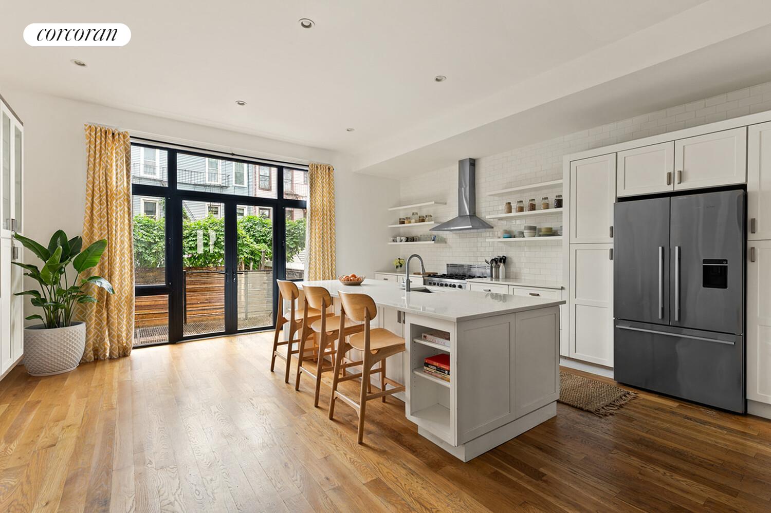 1079 Hancock Street Brooklyn, NY 11221 - Photo 5 of 22 a kitchen with a stove a refrigerator and wooden floor