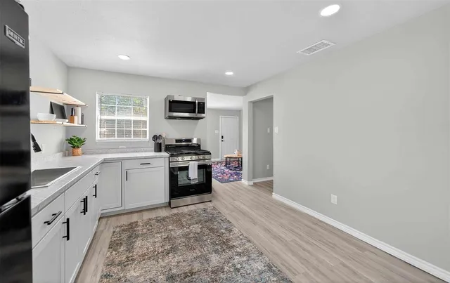 a kitchen with a refrigerator and a stove top oven