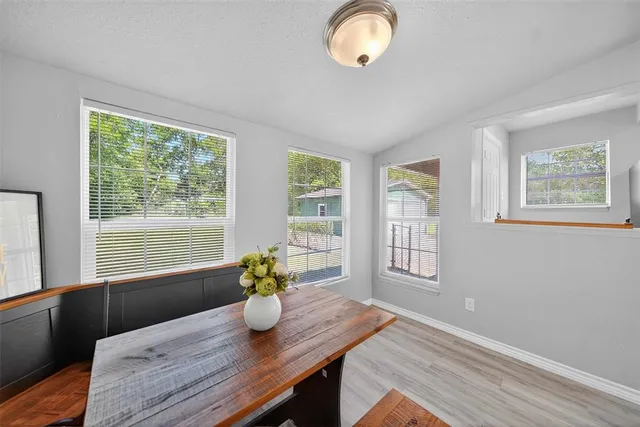 a dining room with wooden floor and windows
