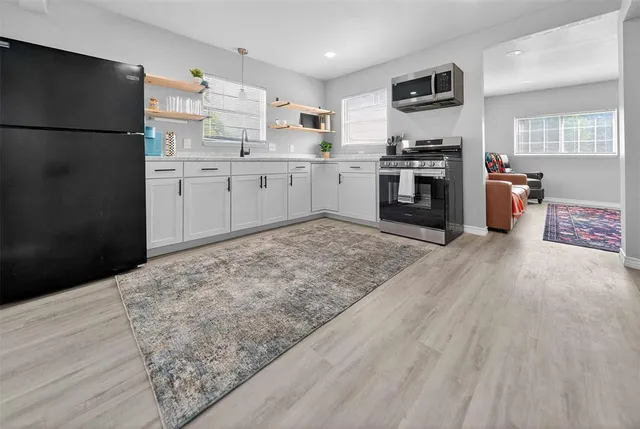 a kitchen with stainless steel appliances granite countertop a sink stove and refrigerator