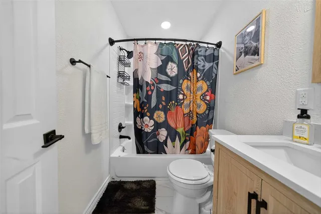 a bathroom with a toilet sink and shower curtain