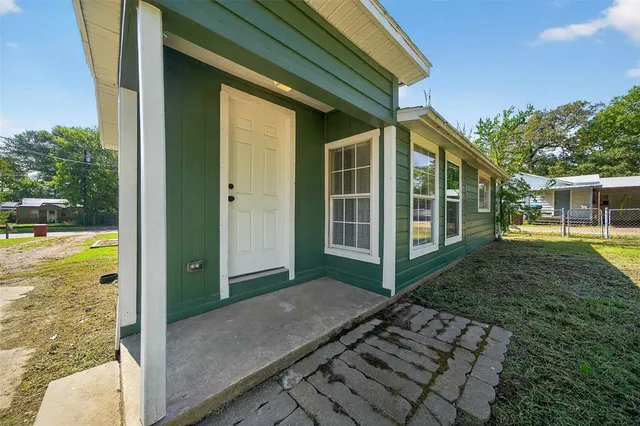 a view of a house with backyard and porch