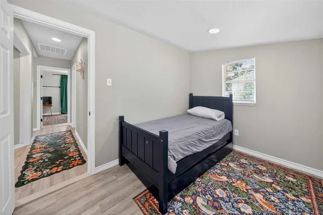 a bedroom with a bed and wooden floor