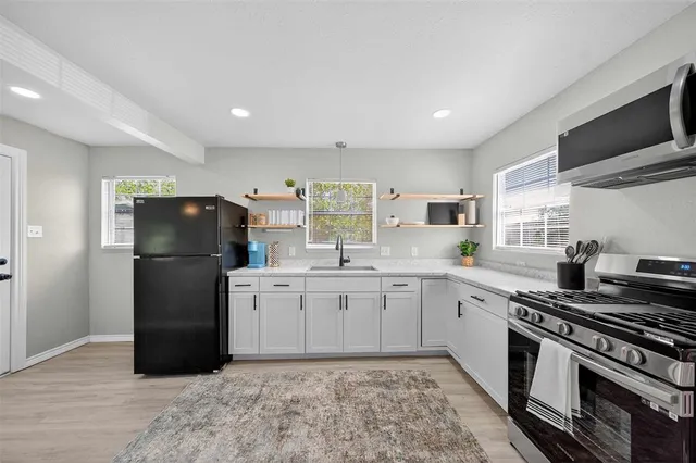 a kitchen with a sink stainless steel appliances and cabinets