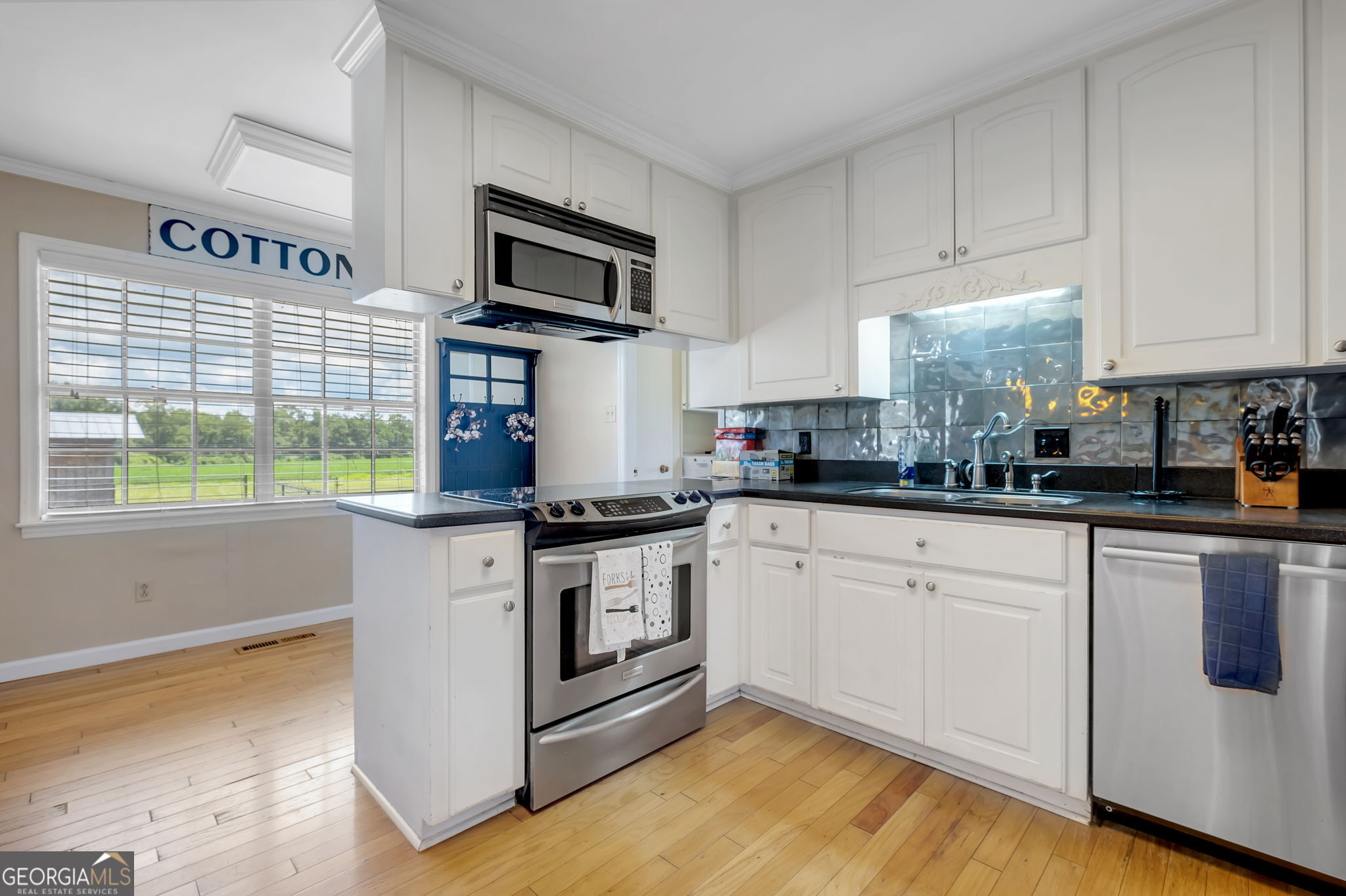 171 Council Lane Cairo, GA 39828 - Photo 26 of 44 a kitchen with granite countertop white cabinets appliances and a window