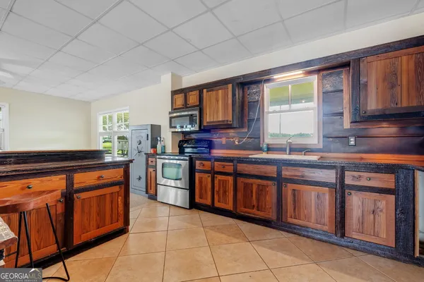 a kitchen with stainless steel appliances granite countertop wooden cabinets a sink and a stove